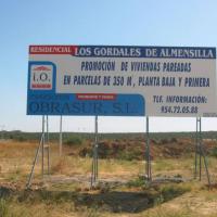 Valla publicitaria o cartelera, así como cartel de obra  panelable y rotulada con vinilo. Obrasur 8x3 Sevilla
