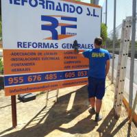Valla publicitaria o cartelera, así como cartel de obra  panelable y rotulada con vinilo. Reformando Dos Hermanas Sevilla