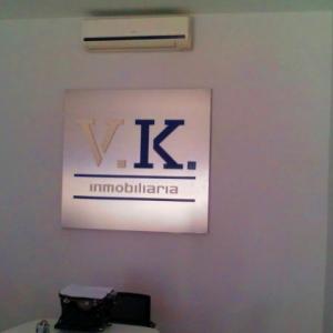 Rótulo en placa de acero inoxidable y letras en pvc. VK Inmobiliarias Sevilla.