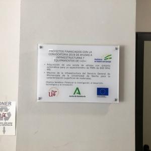 Rótulo en placa de metacrilato rotulada a la inversa. Fondos Feder para la Universidad de Sevilla.
